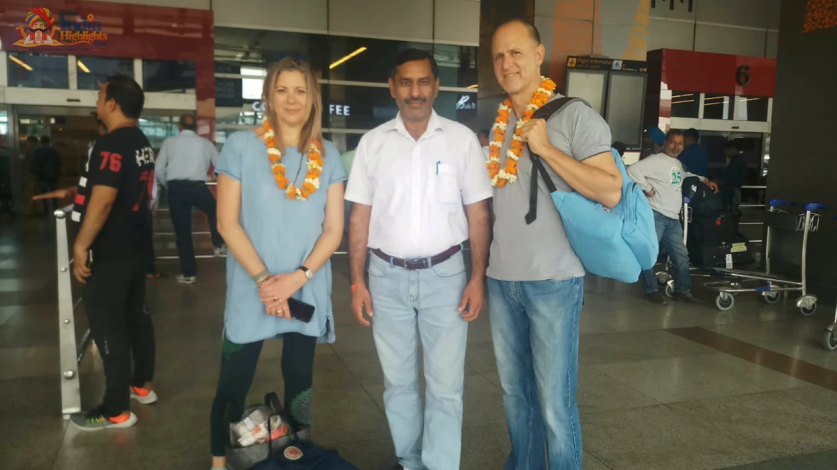 Arrival Greeting & Tour Escort at Airport Terminal Travelers in casual wear adorned with floral garlands posing with India Highlights representative at the airport