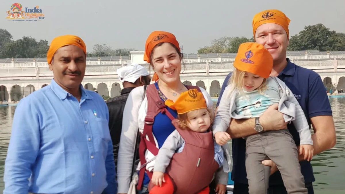Family Cultural Visit to Gurudwara Bangla Sahib, Delhi Foreign family with toddlers wearing saffron head scarves posing beside the sacred sarovar at Gurudwara Bangla Sahib in Delhi