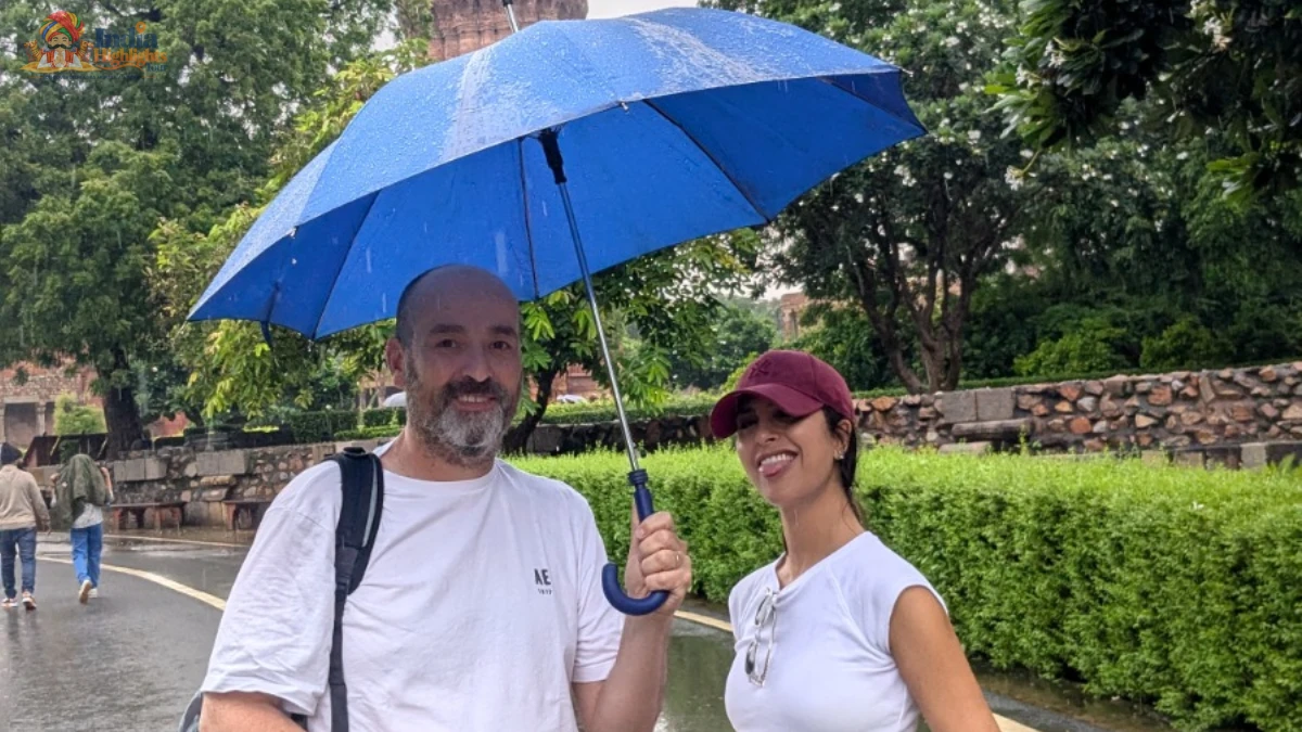 Monsoon Stroll at Qutub Minar Complex, Delhi Couple enjoying a stroll under a blue umbrella on a rainy day at Qutub Minar complex in Delhi